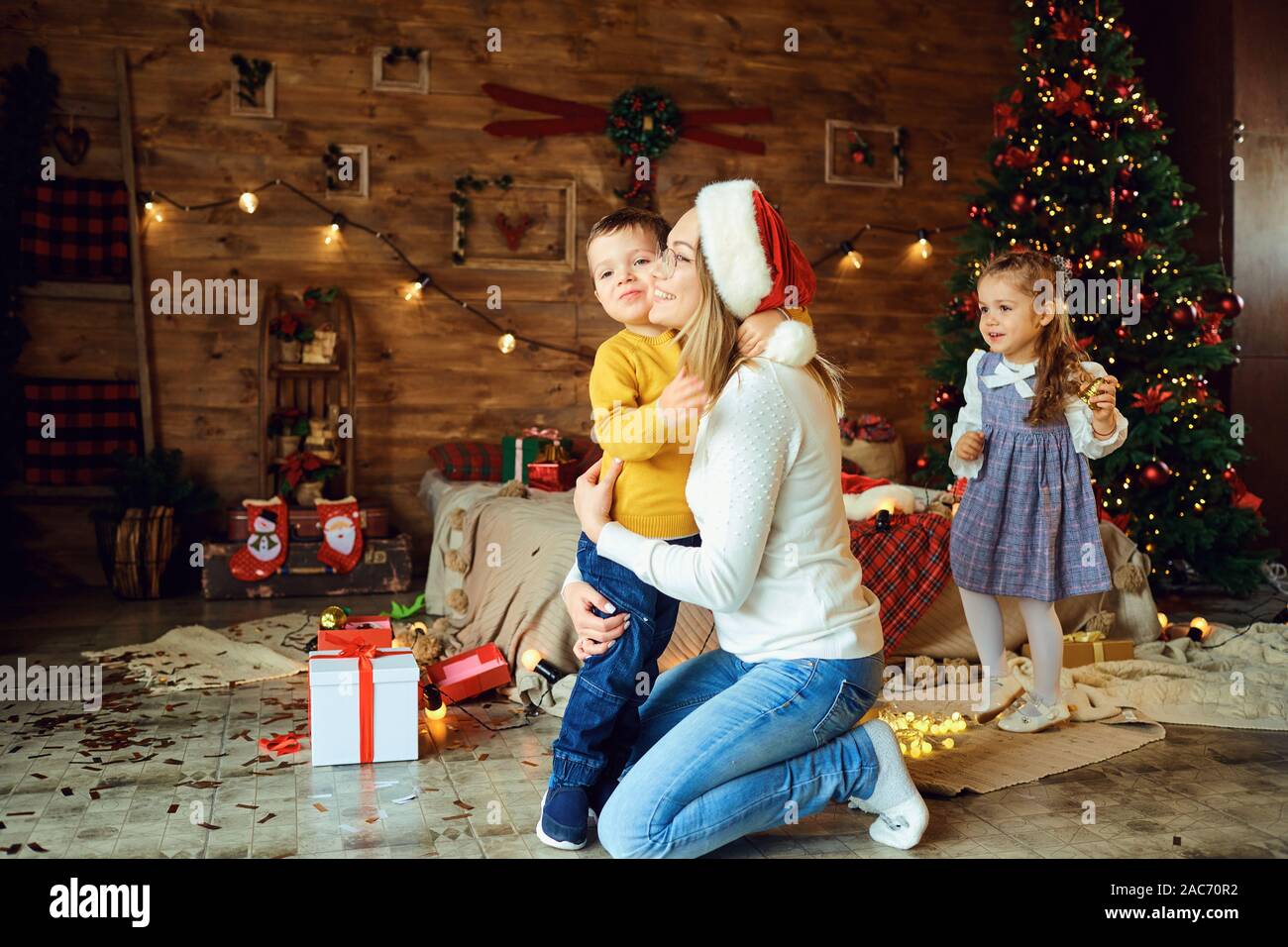 Heureux maman câlins enfants dans une chambre à Noël Banque D'Images