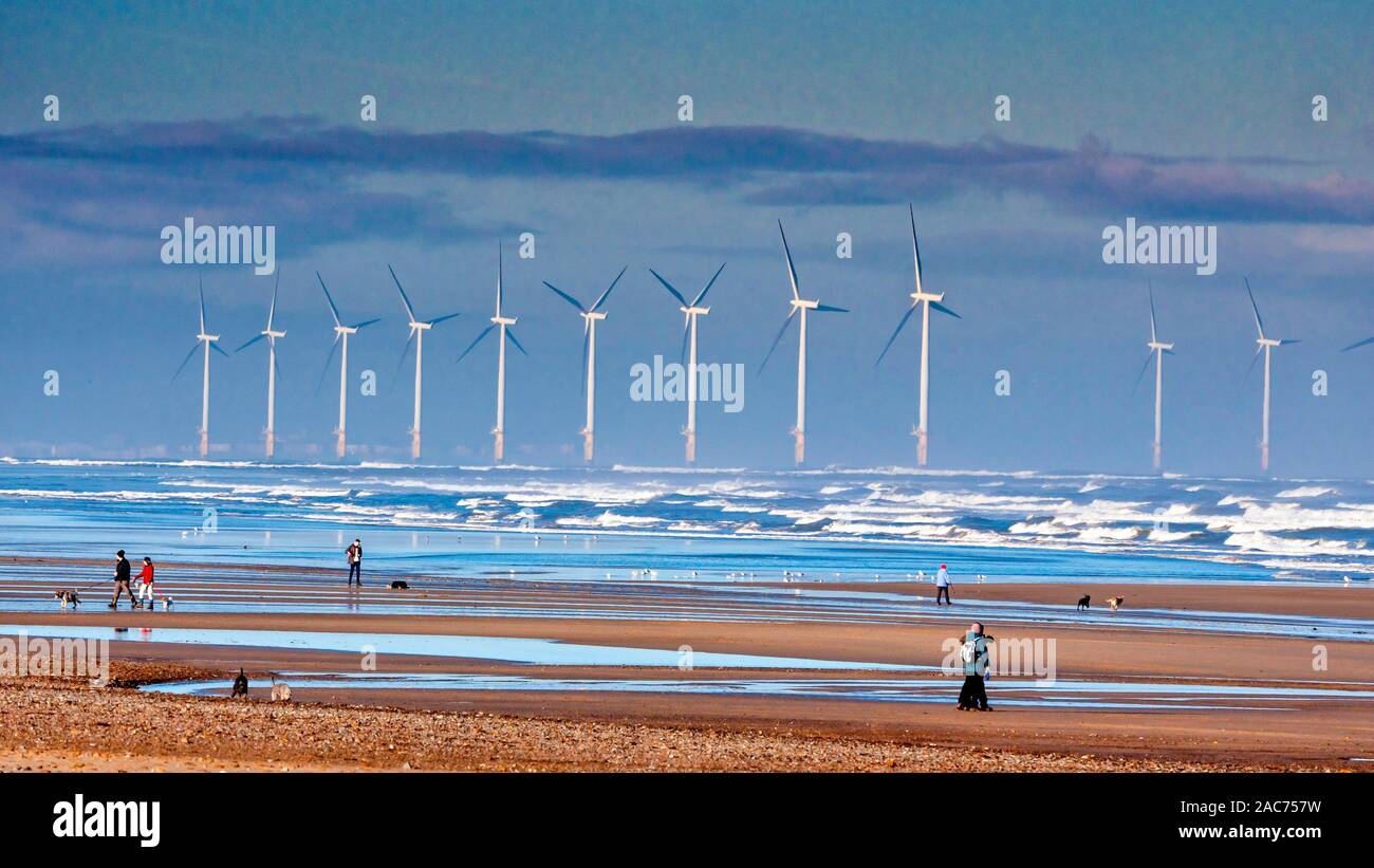 Dog Walkers sur Marske Beach North Yorkshire sur une journée ensoleillée d'automne à marée basse à la recherche vers le nord en direction du parc de Redcar Banque D'Images
