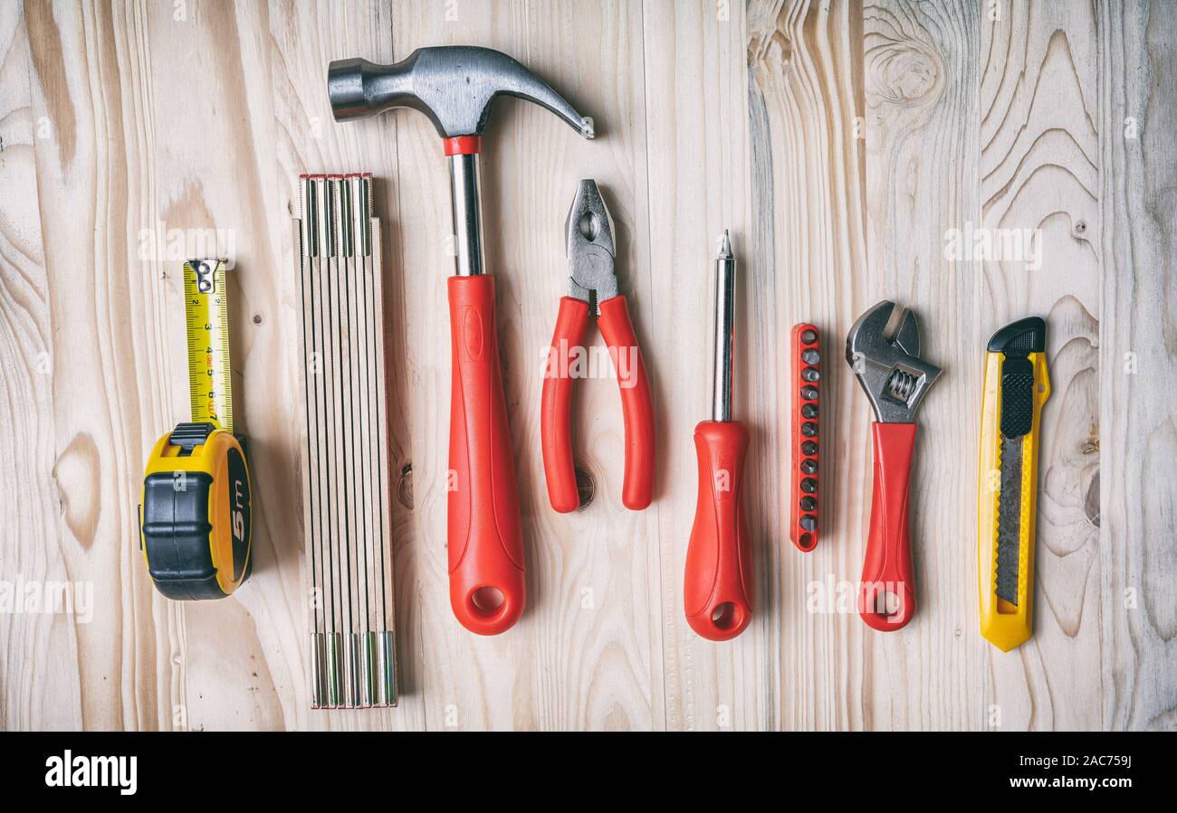 Ensemble d'outils à main de couleur rouge et jaune sur bois, vue du dessus. Bricolage, réparation, service concept. Banque D'Images