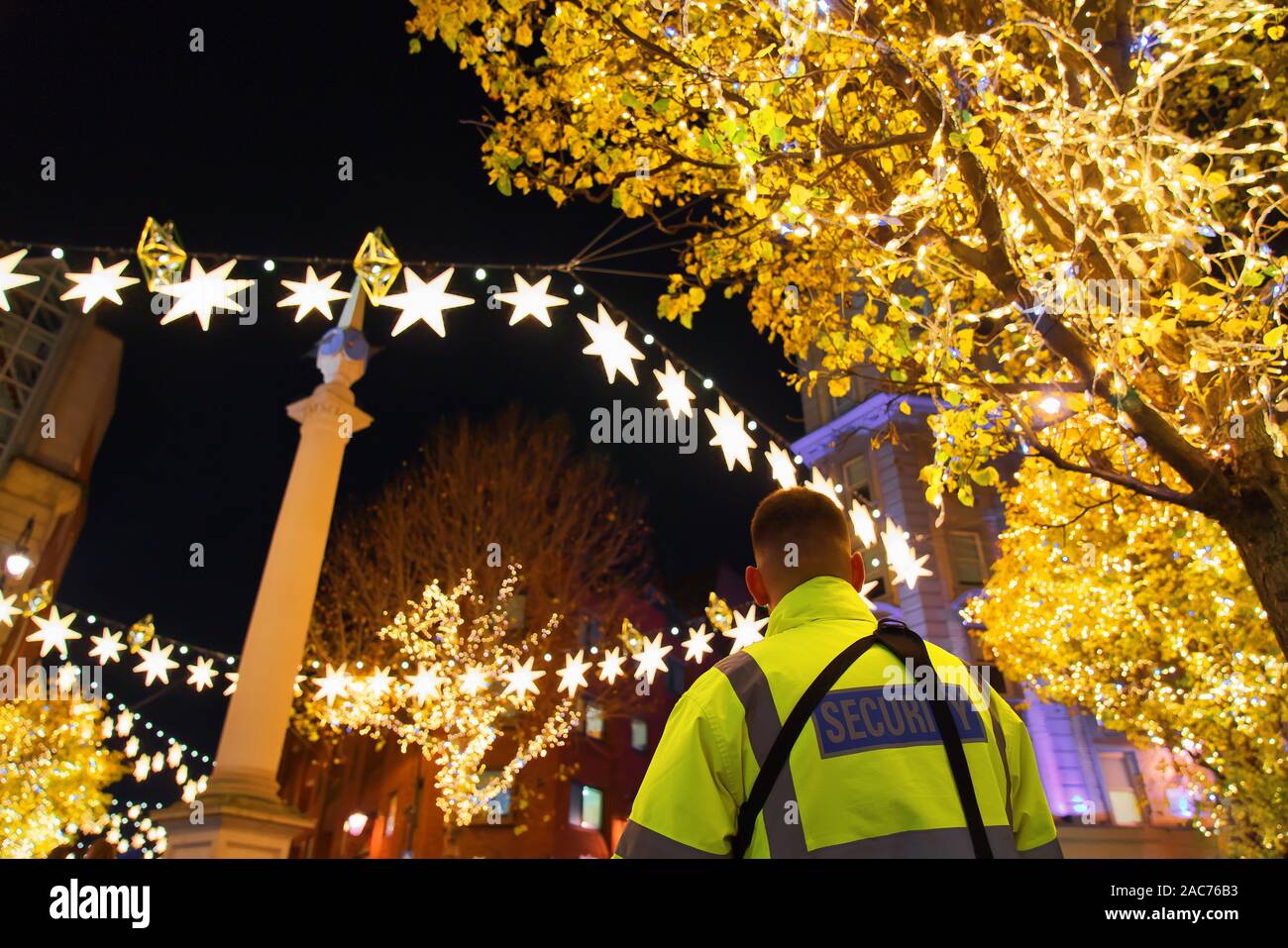 Gardien de sécurité avec yellow jacket en service à Noël à Covent Garden, Londres Banque D'Images