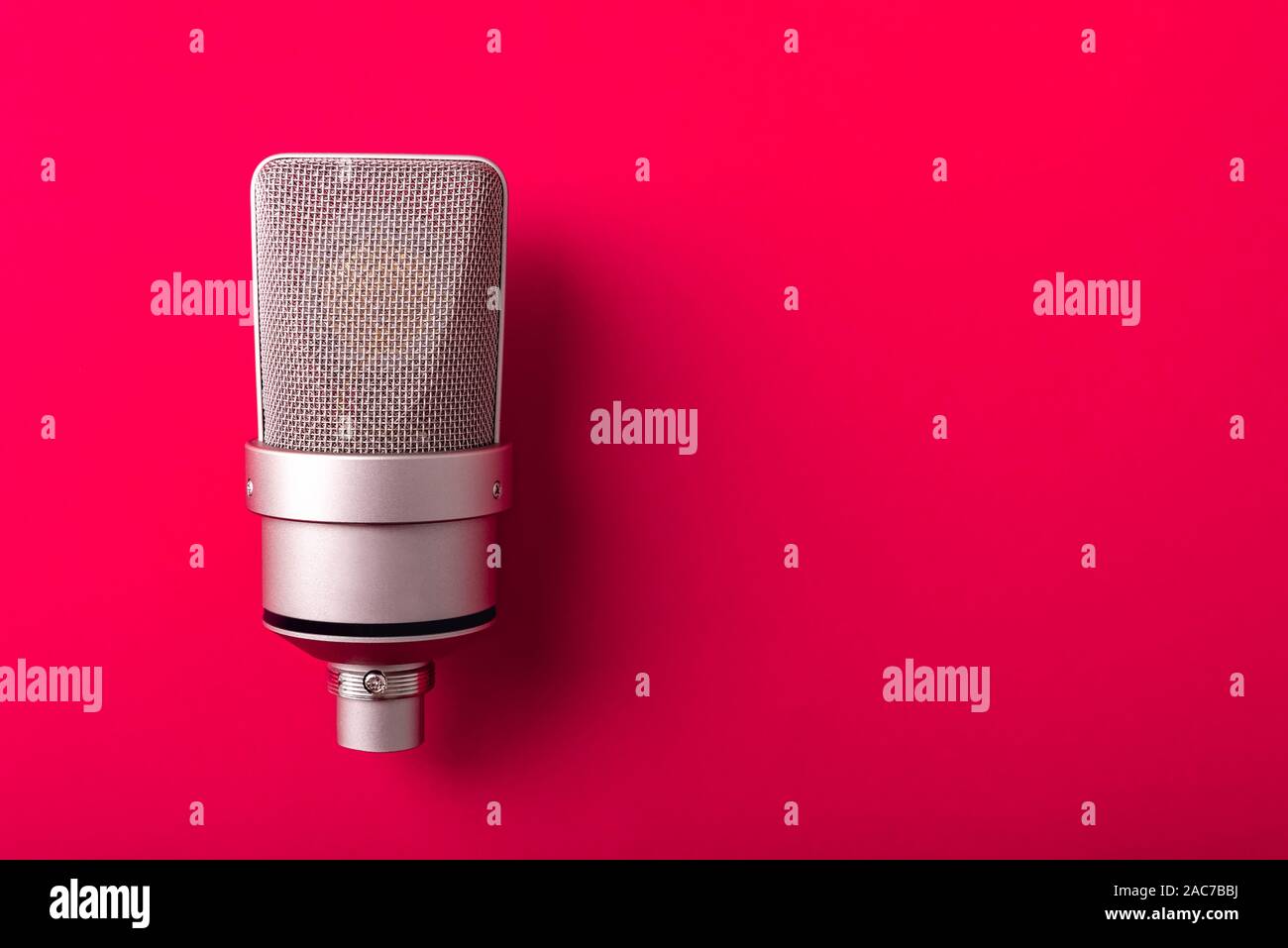 Microphone de studio à condensateur à grand diaphragme. Sur fond rouge. Banque D'Images