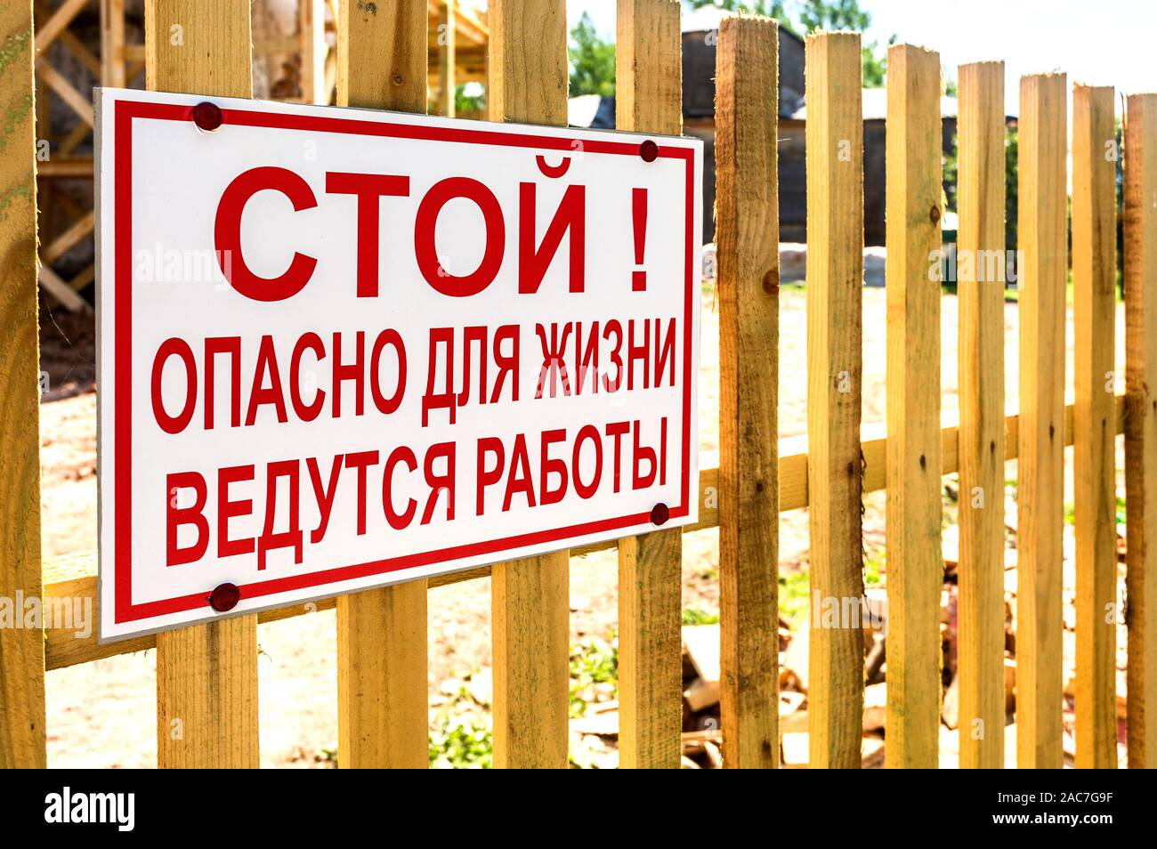 Panneau stop danger sur la clôture en bois. texte en russe : Stop ! Danger pour la vie, zone de travail Banque D'Images