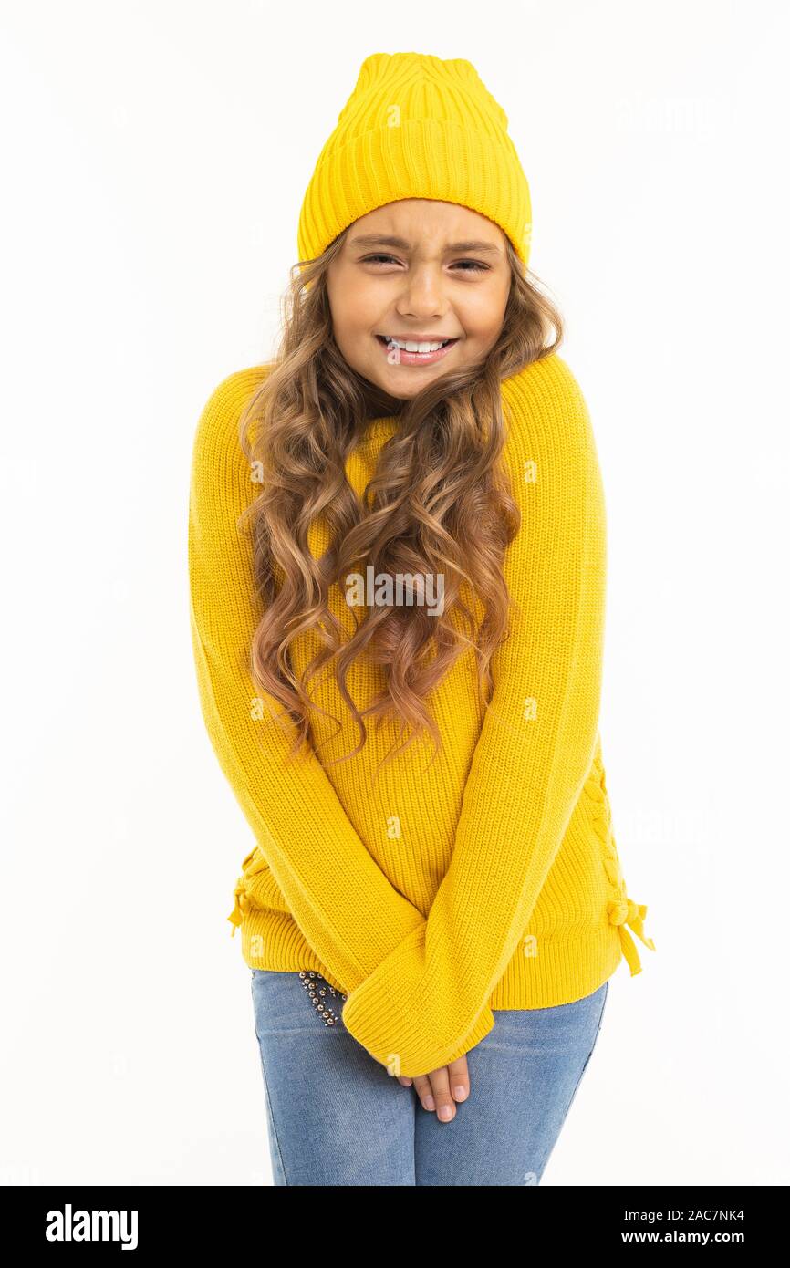 Jolie jeune fille européenne en jaune vêtements smiling mignon sur un fond blanc. Banque D'Images