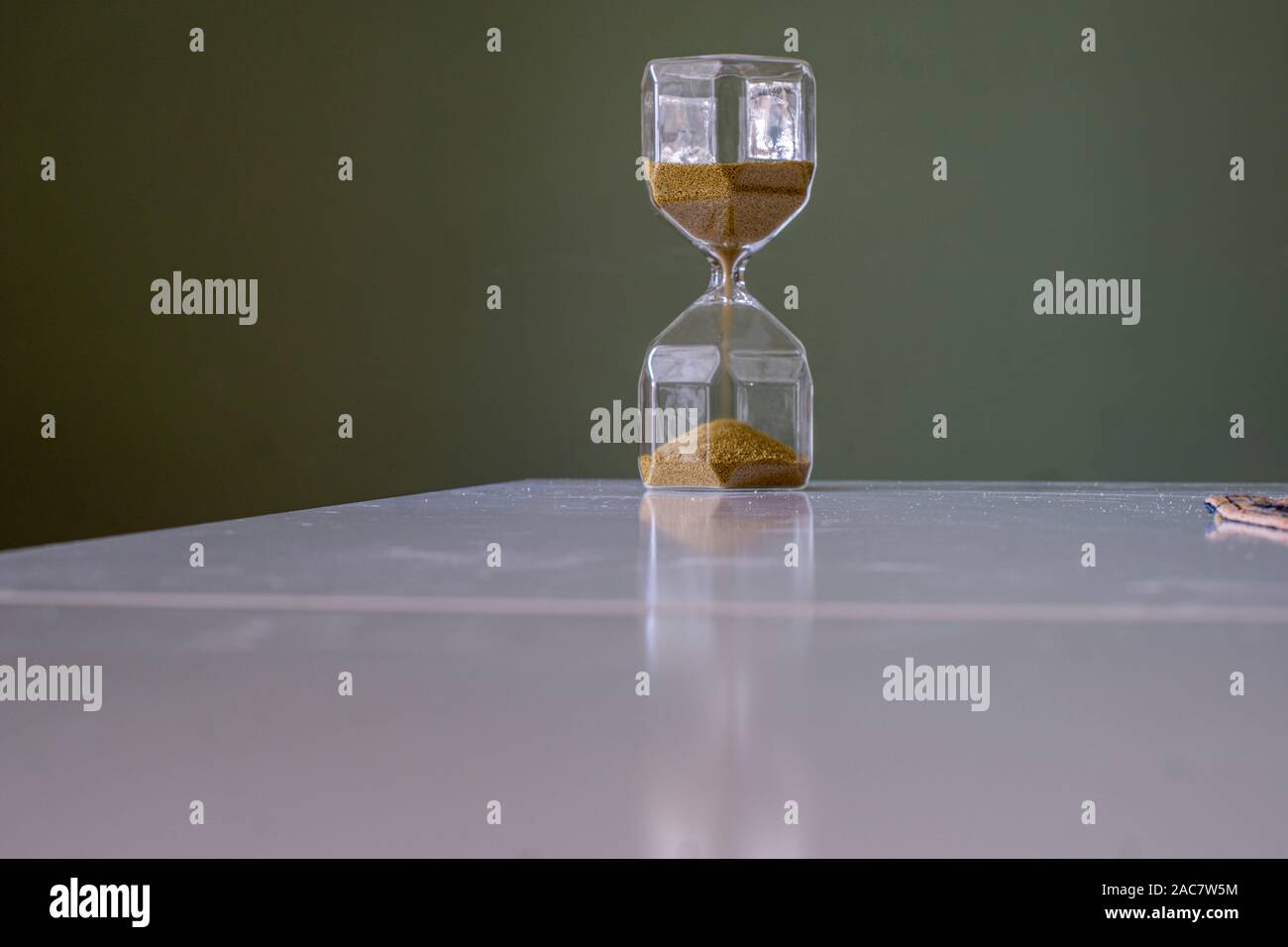 Le sable du sablier chronomètre de table blanche et fond vert Banque D'Images