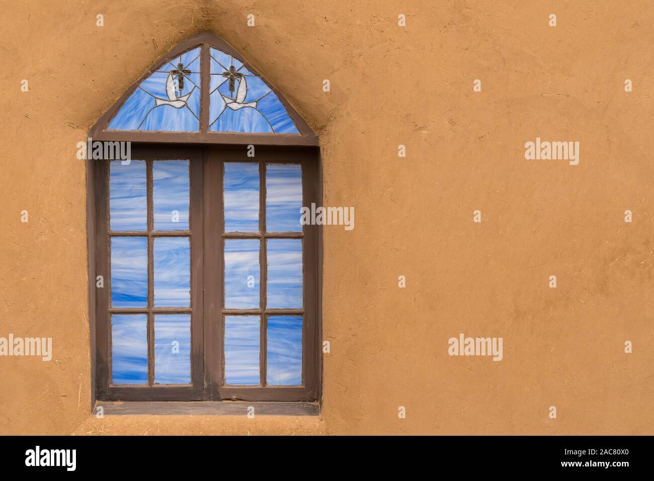 Ancien vitrail à l'extérieur de l'église d'adobe. Banque D'Images