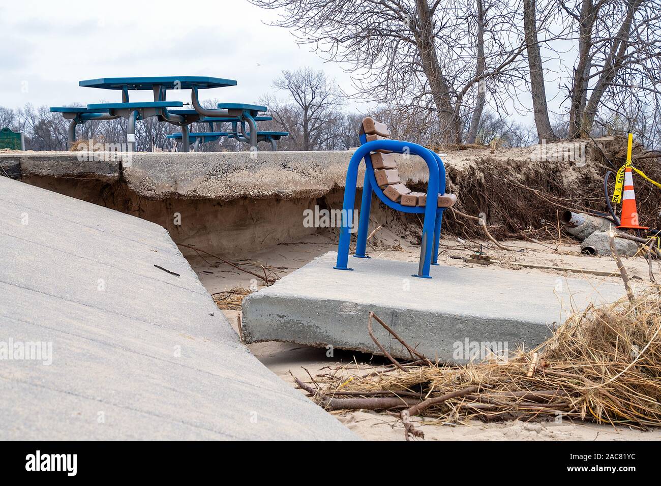 Banc de parc bleu sur une dalle de béton après la tempête Banque D'Images