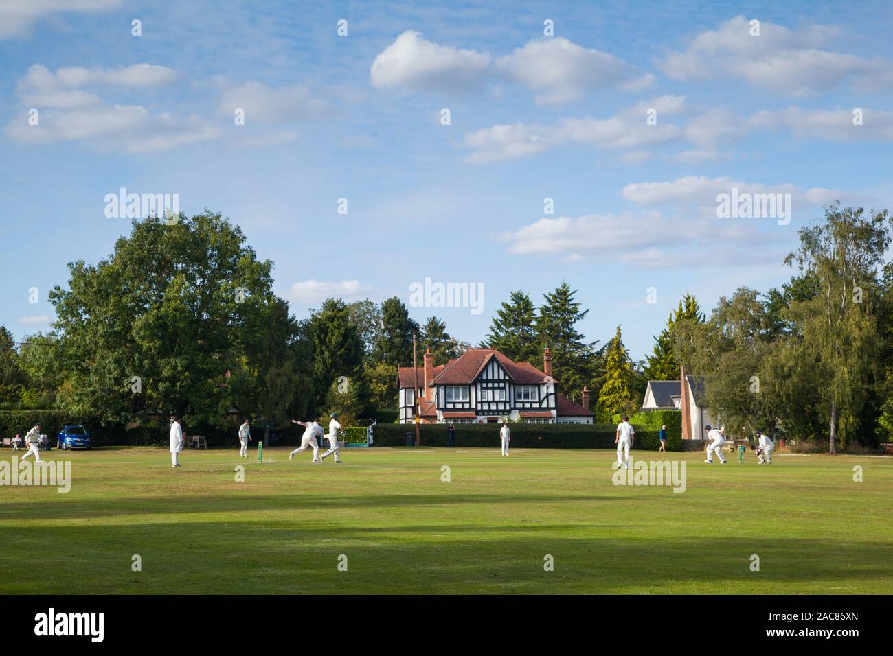 Un traditionnel village anglais de cricket sous un ciel bleu avec des nuages dans le vert sur le cricket à Peppard, Oxfordshire Banque D'Images