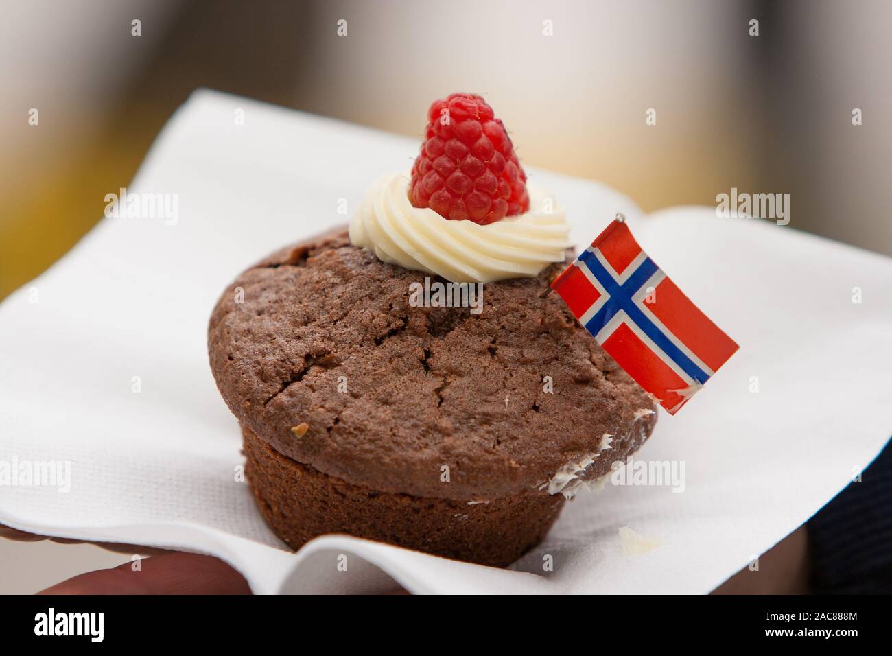 Un petit gâteau au chocolat avec pavillon norvégien sur une serviette blanche. L'ofr Célébration 17 mai. Banque D'Images