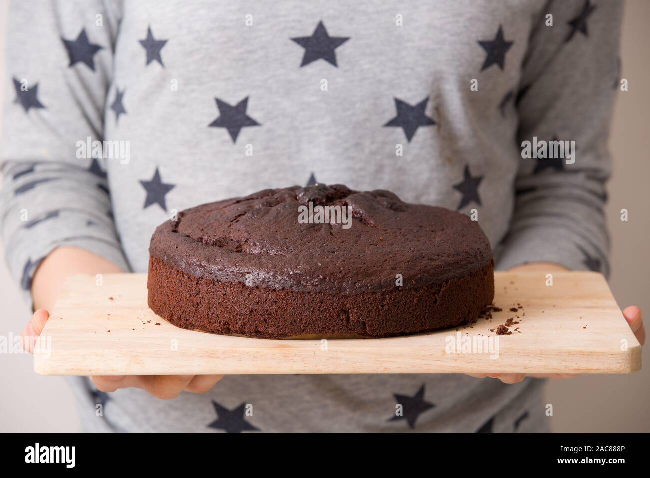 Gâteau d'anniversaire chocolat frais faits maison dans les mains d'une femme. Un beau gâteau pour une partie. Banque D'Images