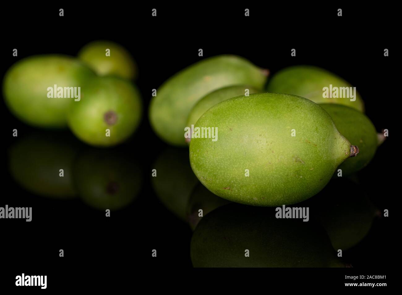 Beaucoup d'hardy kiwi vert isolé sur verre noir Banque D'Images