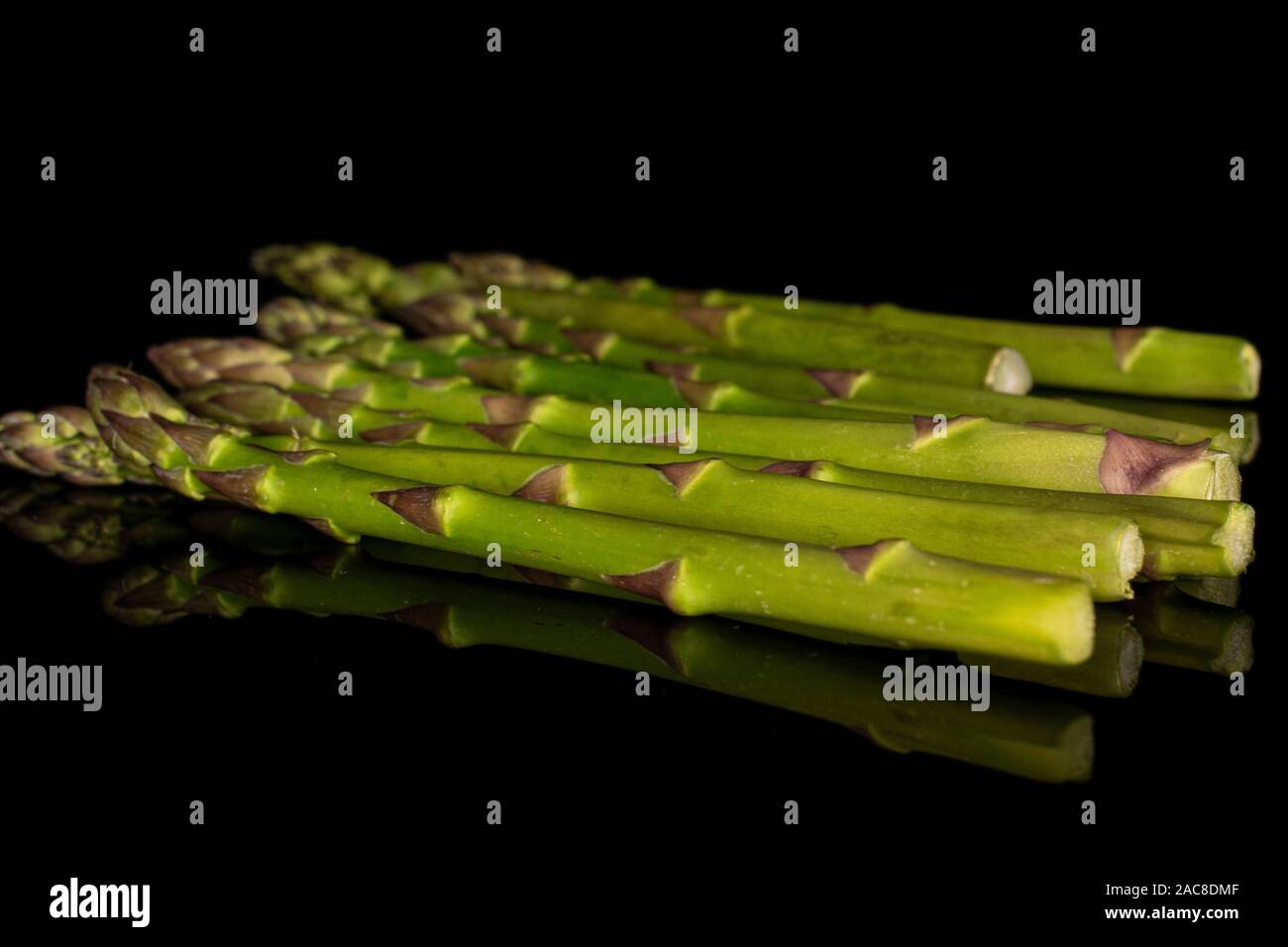Beaucoup d'ensemble organisé d'asperges vertes sain isolé sur verre noir Banque D'Images