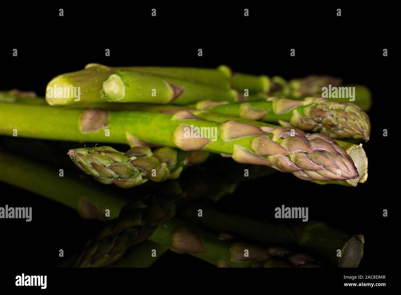 Beaucoup d'ensemble frais sain isolé sur les asperges vertes en verre noir Banque D'Images