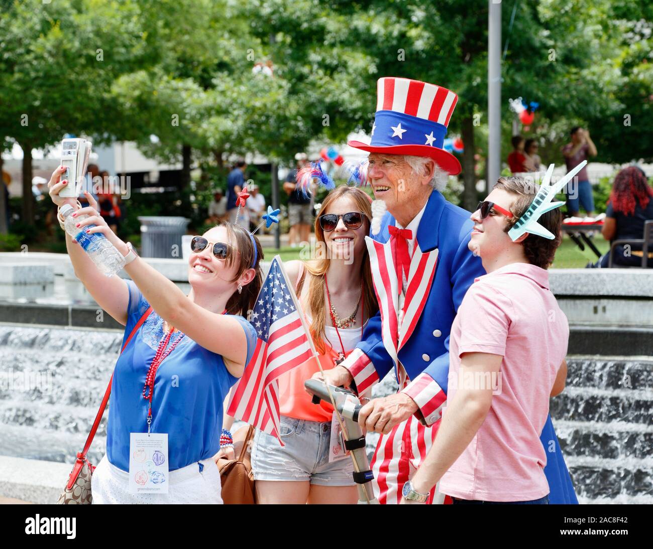 Les jeunes qui pose pour un oncle Sam avec selfies le 4 juillet, fête événement à Greensboro, NC, États-Unis d'Amérique, Banque D'Images