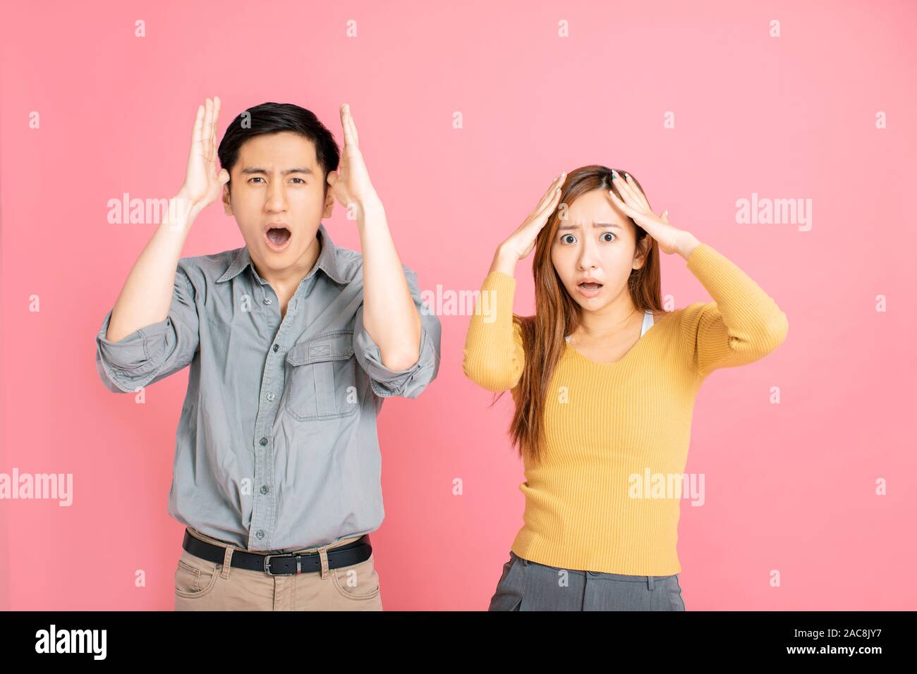 Jeune couple peur et choqué avec expression surprise Banque D'Images