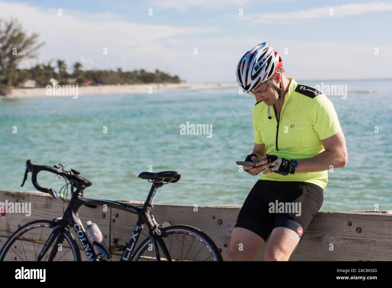 Un cycliste prend une pause de son morning ride pour contrôler son téléphone en floride Banque D'Images