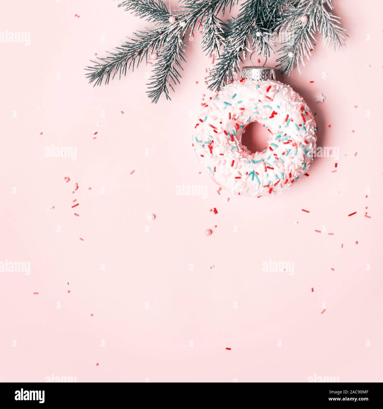 Concept créatif de Noël avec balle faite de donut sur fond rose, copiez l'espace. Banque D'Images