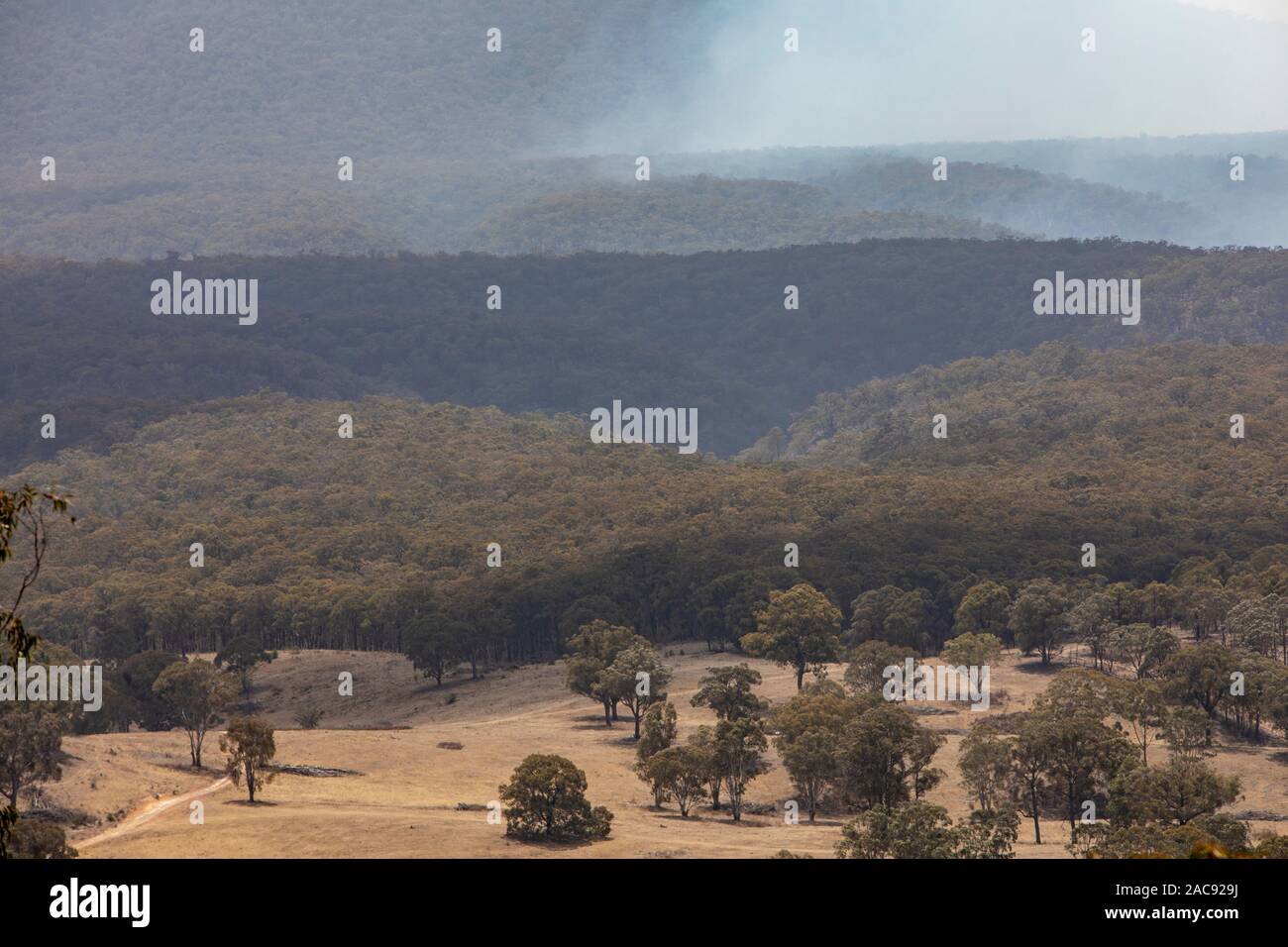 Capertee Valley près de Blue Mountains en été, la fumée avant de bush à travers la vallée, New South Wales, Australie Banque D'Images