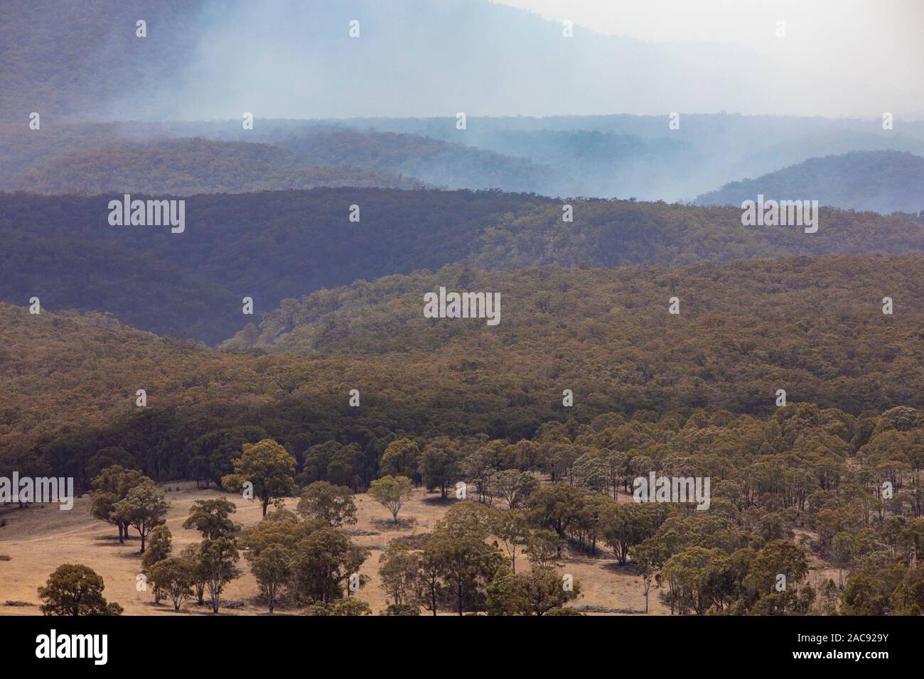 Capertee Valley près de Blue Mountains en été, la fumée avant de bush à travers la vallée, New South Wales, Australie Banque D'Images
