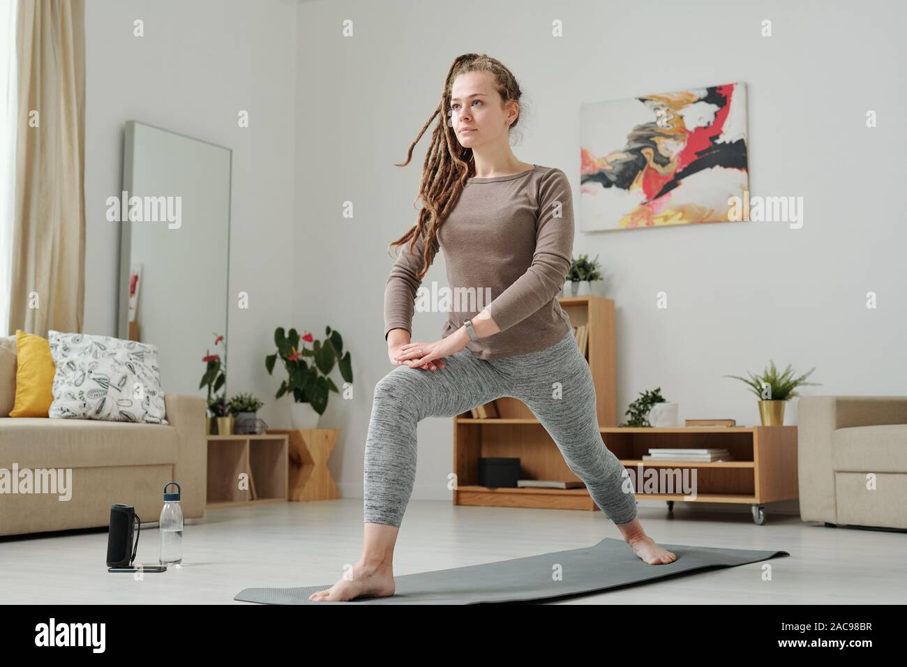 Barefoot Active femelle en étirant les jambes et leggins gilet tout en exerçant Banque D'Images