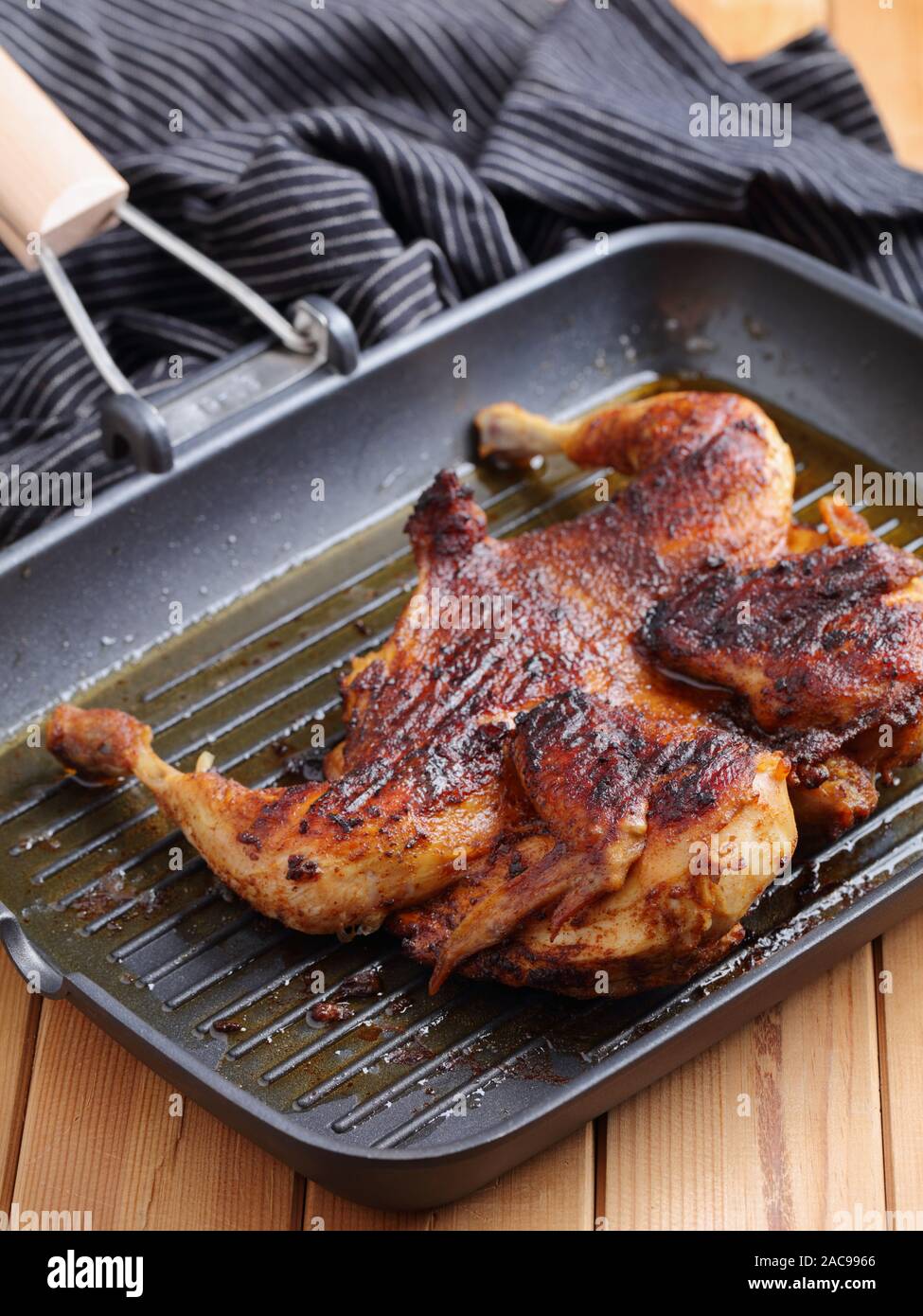 La cuisson du poulet dans une brique, également connu sous le nom de brick poulet, ou pollo al mattone, sur un gril Banque D'Images