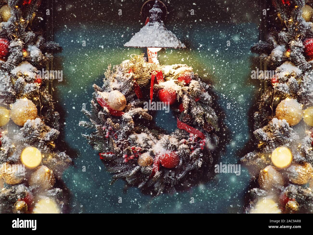 Couronne de Noël sur la porte verte par temps de neige. Banque D'Images