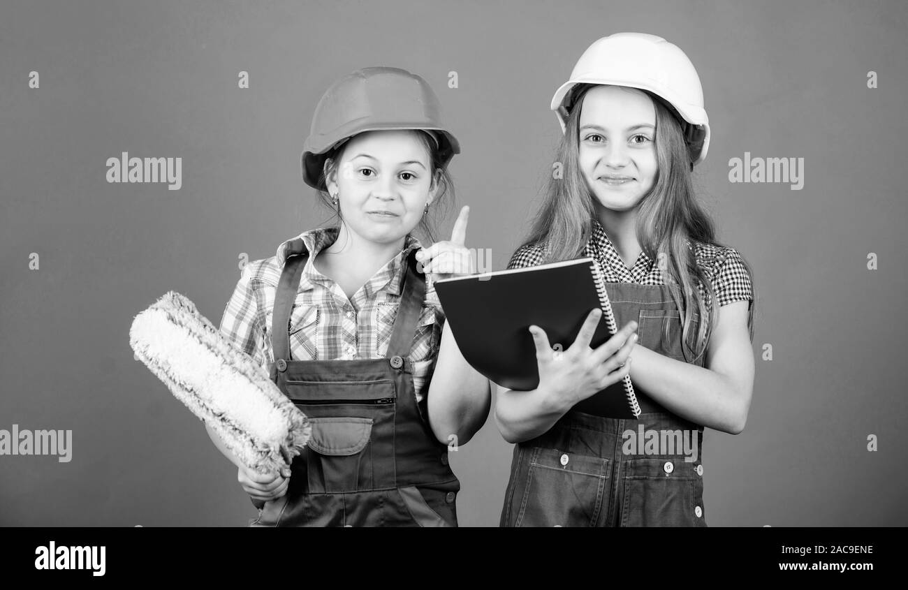 Les petits enfants en casque avec tablet et rouleau. petites filles réparer ensemble en atelier. idée de génie. La fête du travail. 1 mai. Inspecteur de contremaître. Repai Banque D'Images