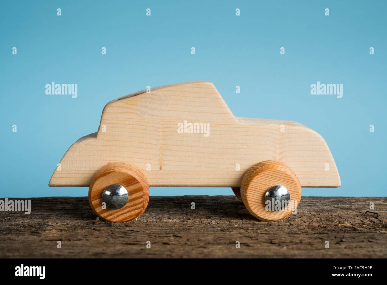 Voiture jouet en bois faits à la main sur un fond bleu clair Banque D'Images