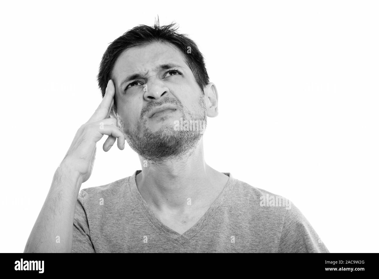 Studio shot of young man thinking et looking up Banque D'Images