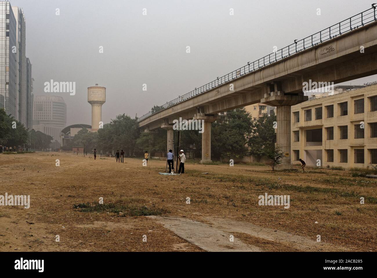 Même le malsain Delhi ne peut pas arrêter le smog l'Inde ces gars jouer au cricket sur la masse des déchets à Gurgaon. Banque D'Images
