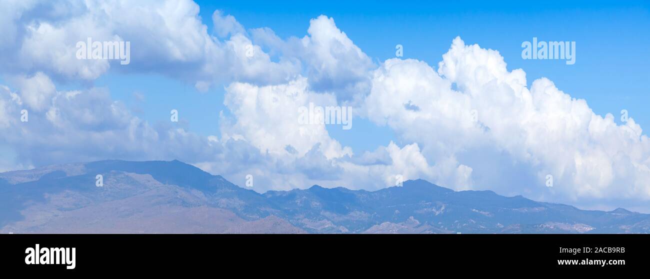Paysage de montagne avec des cumulus blancs dans le ciel bleu dans la journée. Contexte photo panoramique naturel Banque D'Images