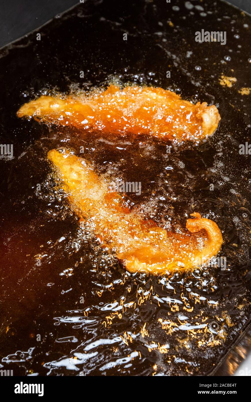 Faites cuire du poisson dans une friteuse à graisse profonde dans une boutique de poissons et de copeaux au Royaume-Uni Banque D'Images