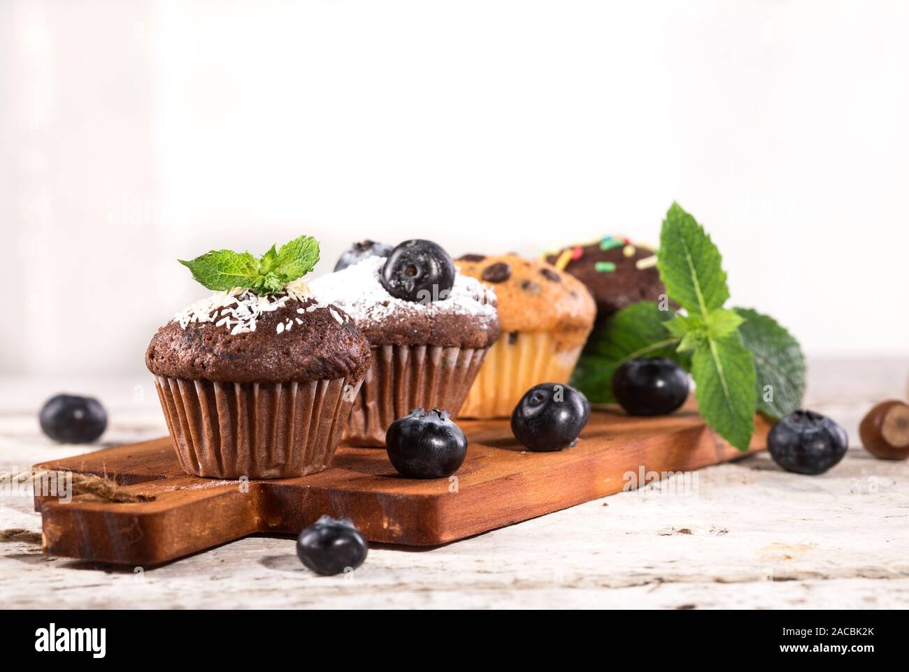Muffins aux bleuets et chocolat blanc sur un fond de bois. Banque D'Images