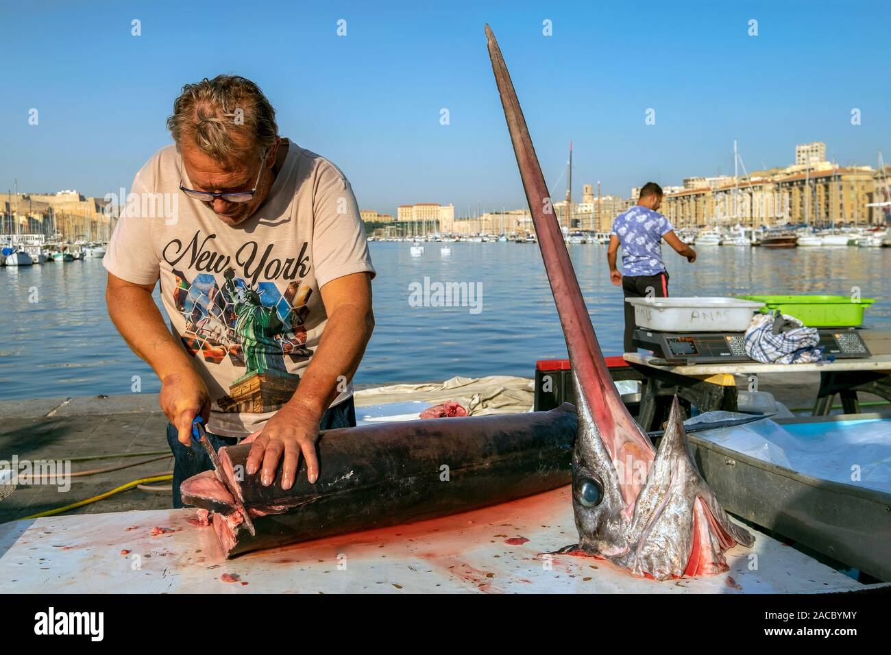 Un pêcheur découpant l'espadon du marché aux poissons dans le Vieux Port de Marseille / Vieux Port de Marseille, Provence, France, Europe Banque D'Images
