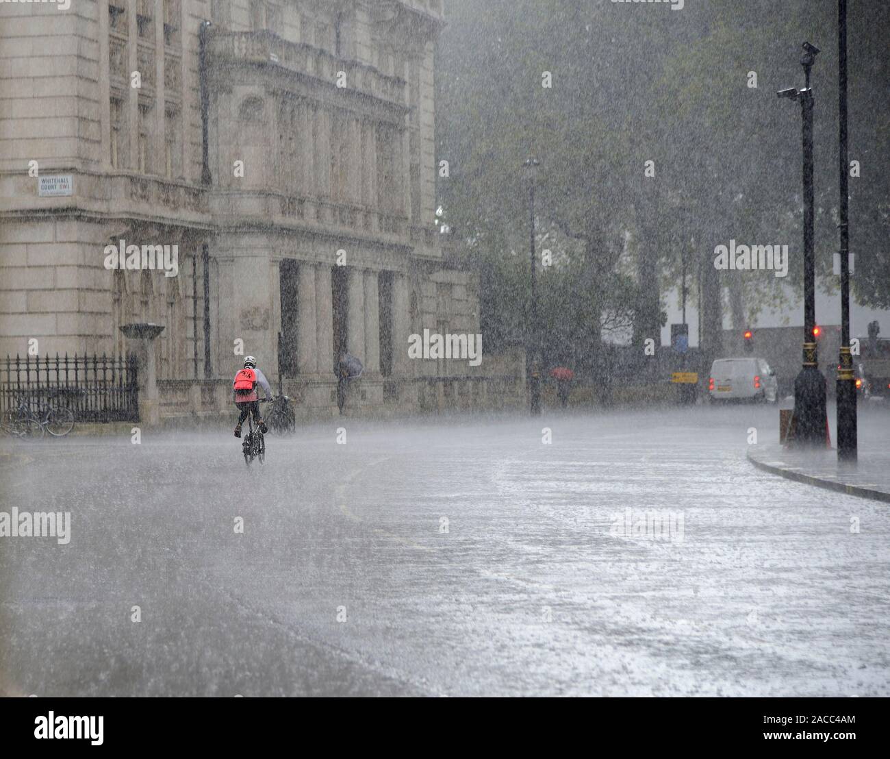 Londres, Angleterre, Royaume-Uni. Cycliste à la pluie torrentielle Banque D'Images