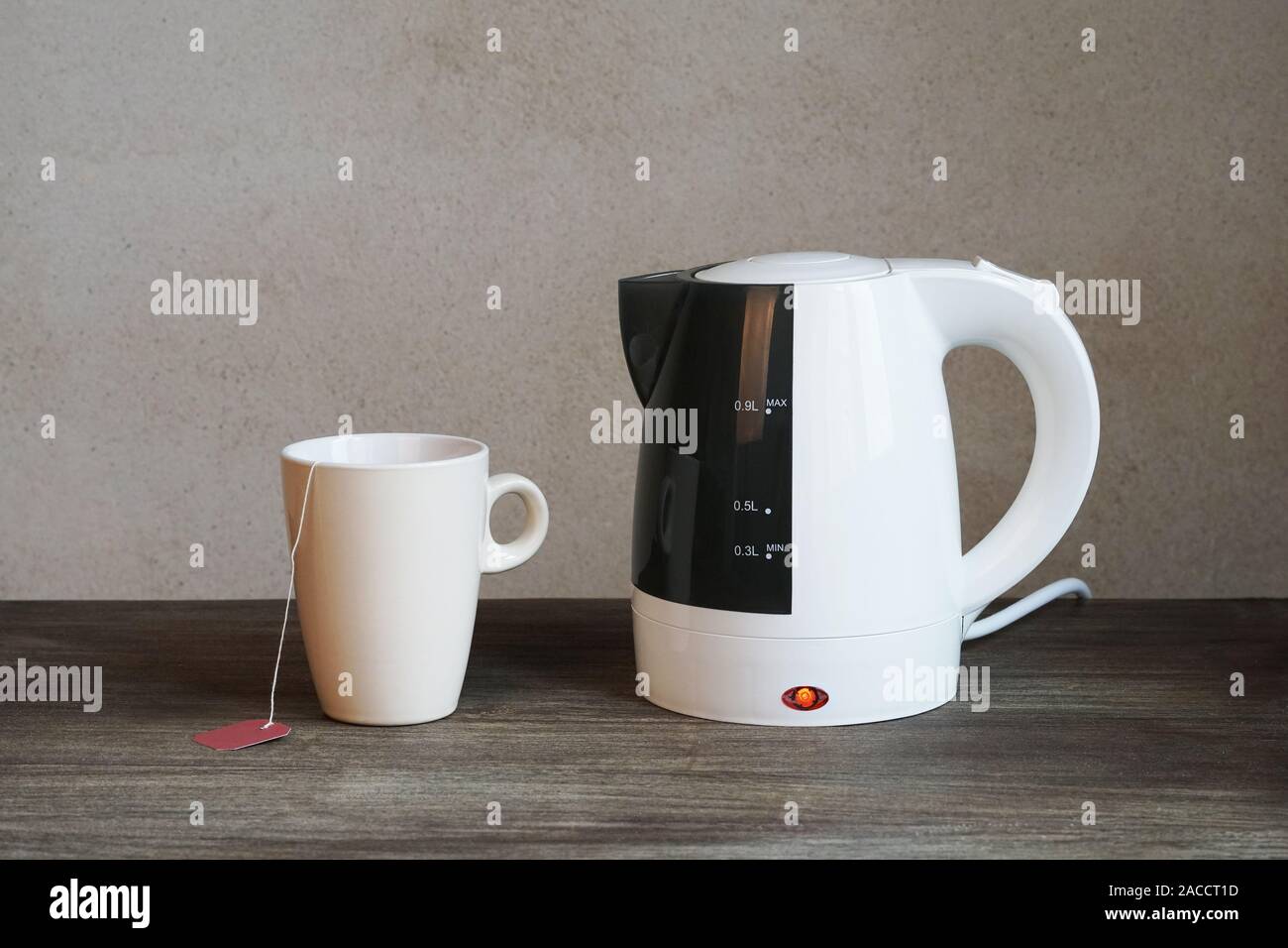 Plateau avec bouilloire électrique, tasse et sachet de thé Photo Stock -  Alamy