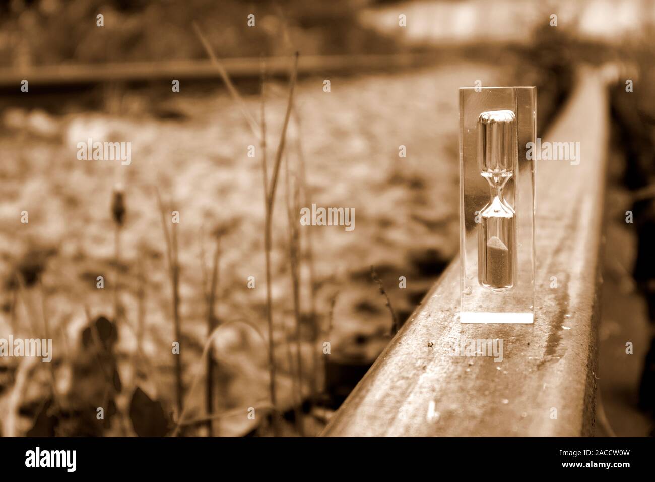 Hourglass transparent debout sur la old rusty rail en sépia, concept de temps Banque D'Images