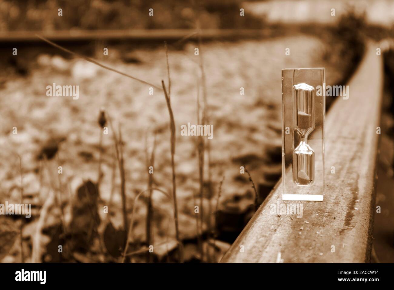 Hourglass transparent debout sur la old rusty rail en sépia, concept de temps Banque D'Images