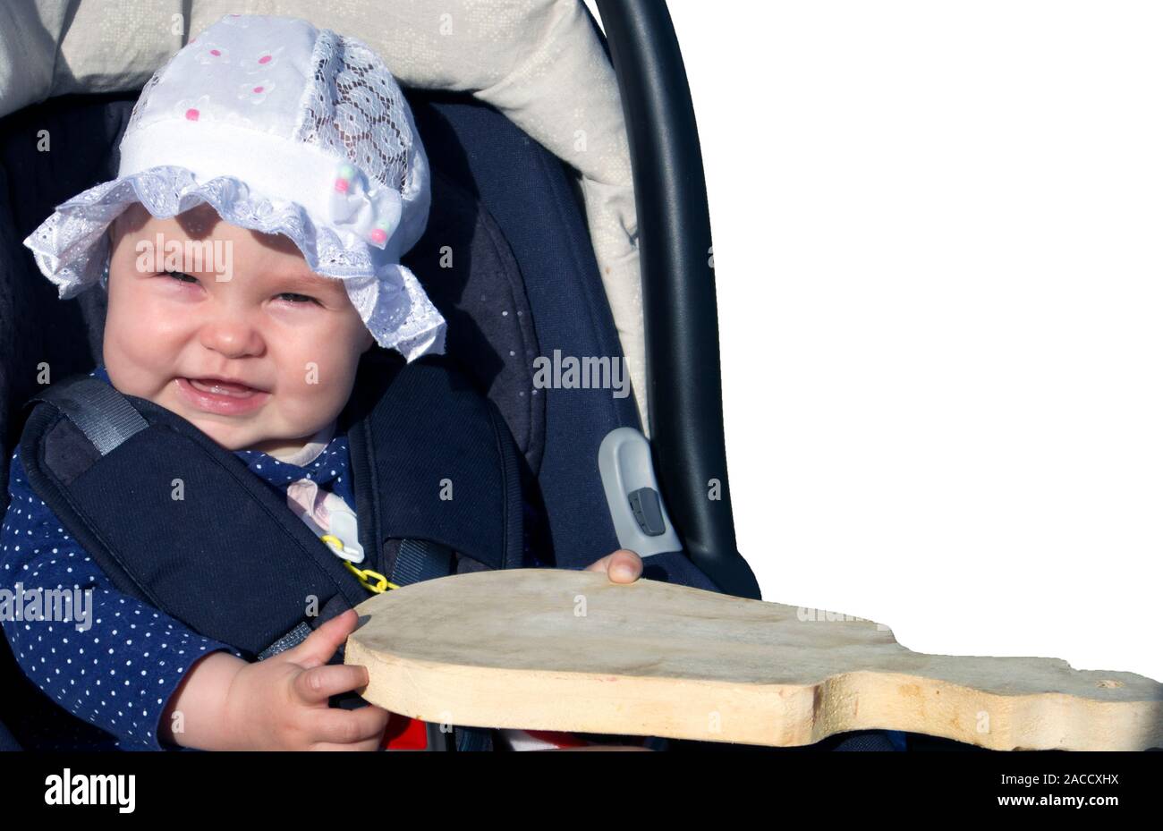 Adorable petite fille souriante vêtue d'un capuchon avec volants jouant avec planche à découper Banque D'Images