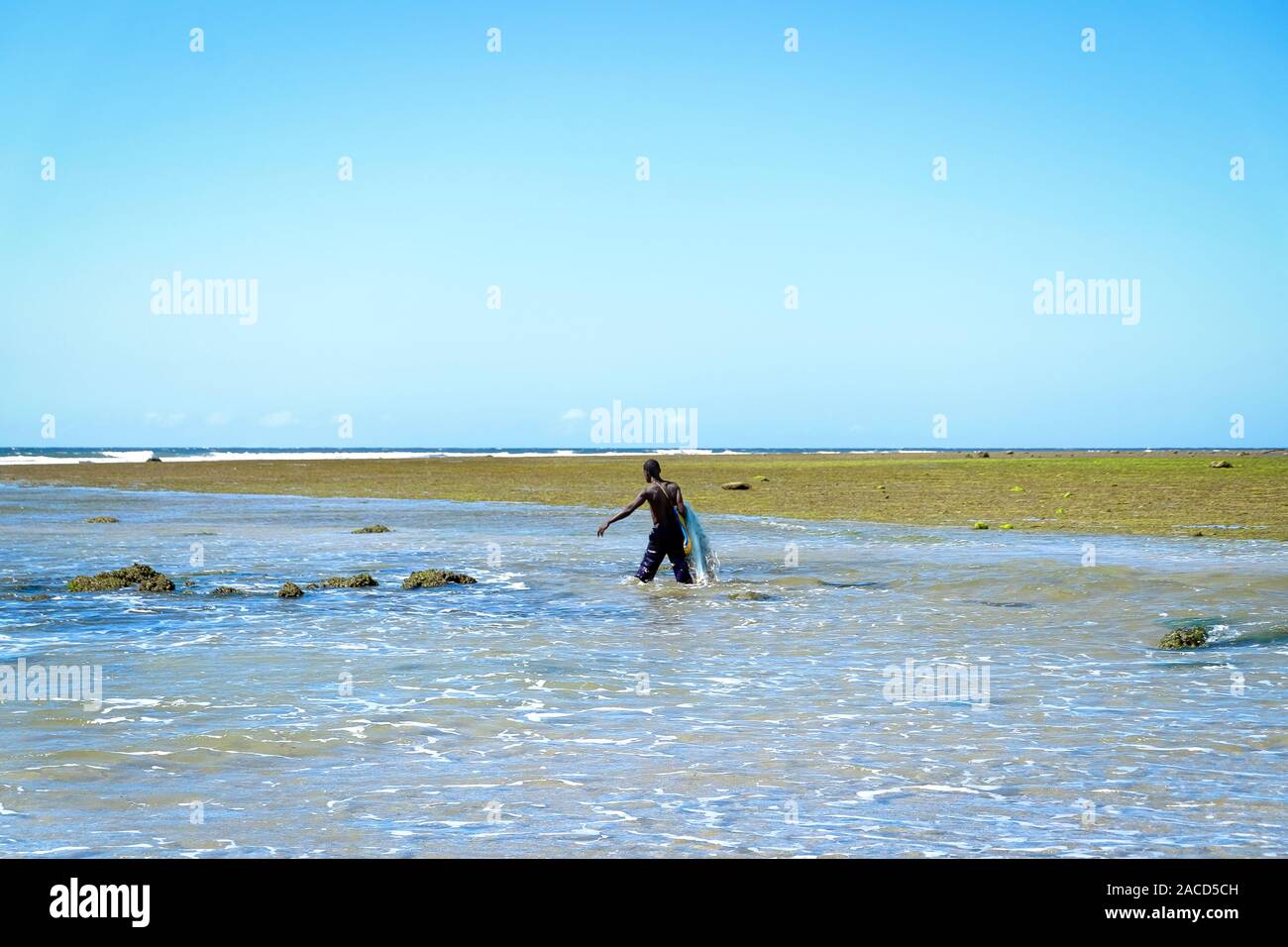 Pêcheur africain en eau peu profonde avec son filet de pêche Banque D'Images