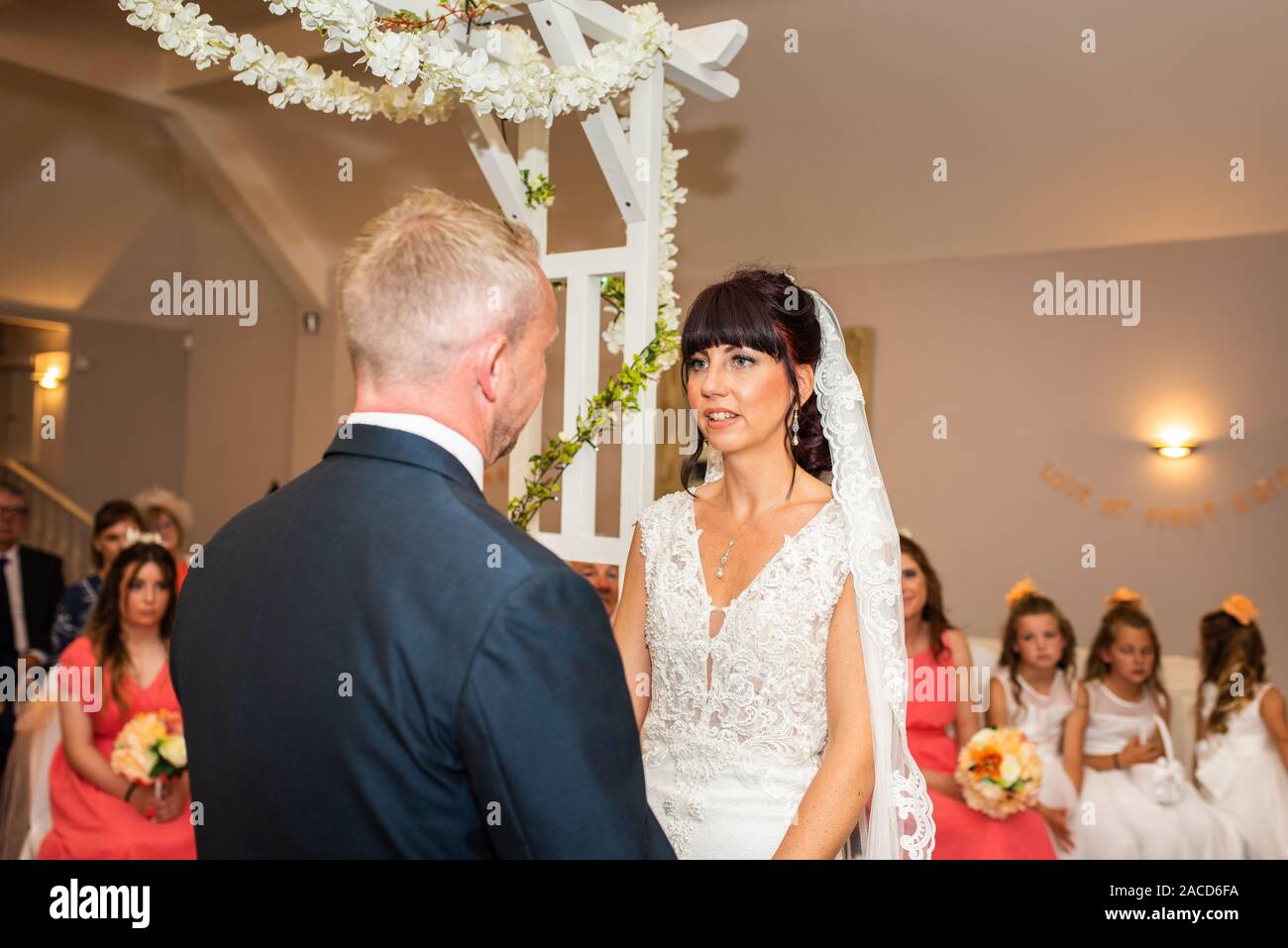 Un couple se marie à l'intérieur lors d'une cérémonie de mariage anglaise traditionnelle au Manor, B & B, Hôtel à Cheadle, Stoke on Trent, Staffordshire Banque D'Images