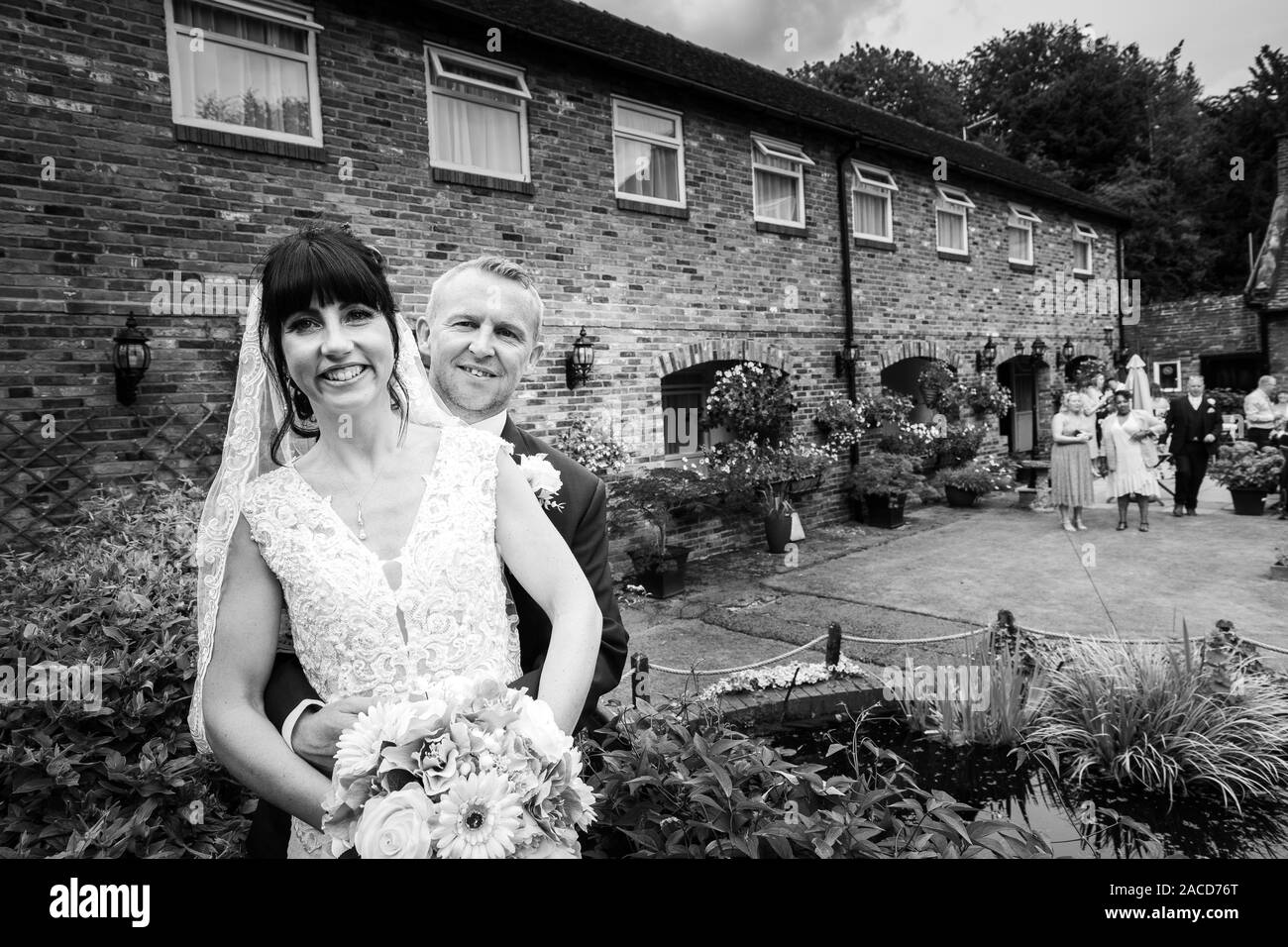 Mariés et mariés posent pour leurs photos après la cérémonie dans les jardins de l'hôtel Manor, B & B à Cheadle, Stoke on Trent, Staffordshire, jour du mariage Banque D'Images