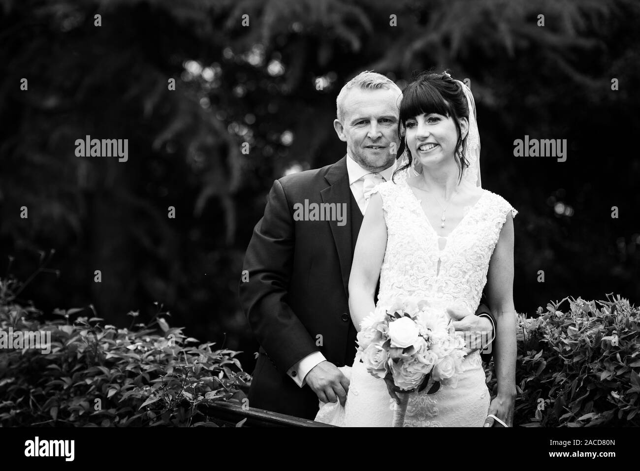 Mariés et mariés posent pour leurs photos après la cérémonie dans les jardins de l'hôtel Manor, B & B à Cheadle, Stoke on Trent, Staffordshire, jour du mariage Banque D'Images