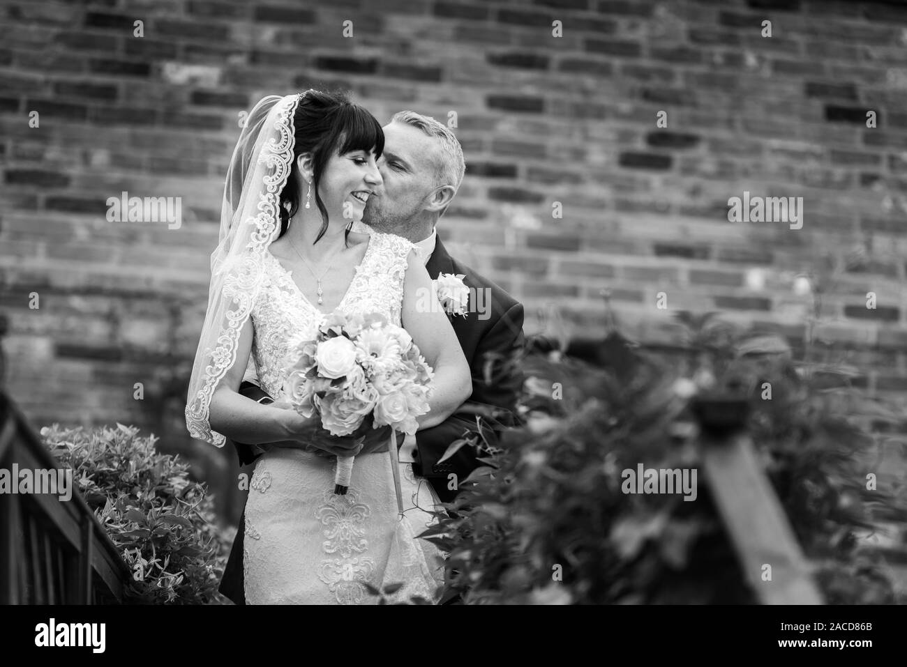 Mariés et mariés posent pour leurs photos après la cérémonie dans les jardins de l'hôtel Manor, B & B à Cheadle, Stoke on Trent, Staffordshire, jour du mariage Banque D'Images