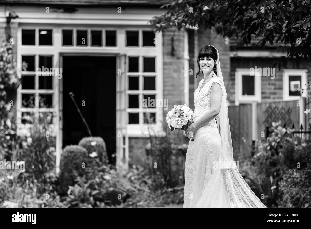 Une mariée pose pour elle après des photos de cérémonie dans les jardins de l'hôtel Manor, B & B à Cheadle, Stoke on Trent, Staffordshire, jour du mariage Banque D'Images