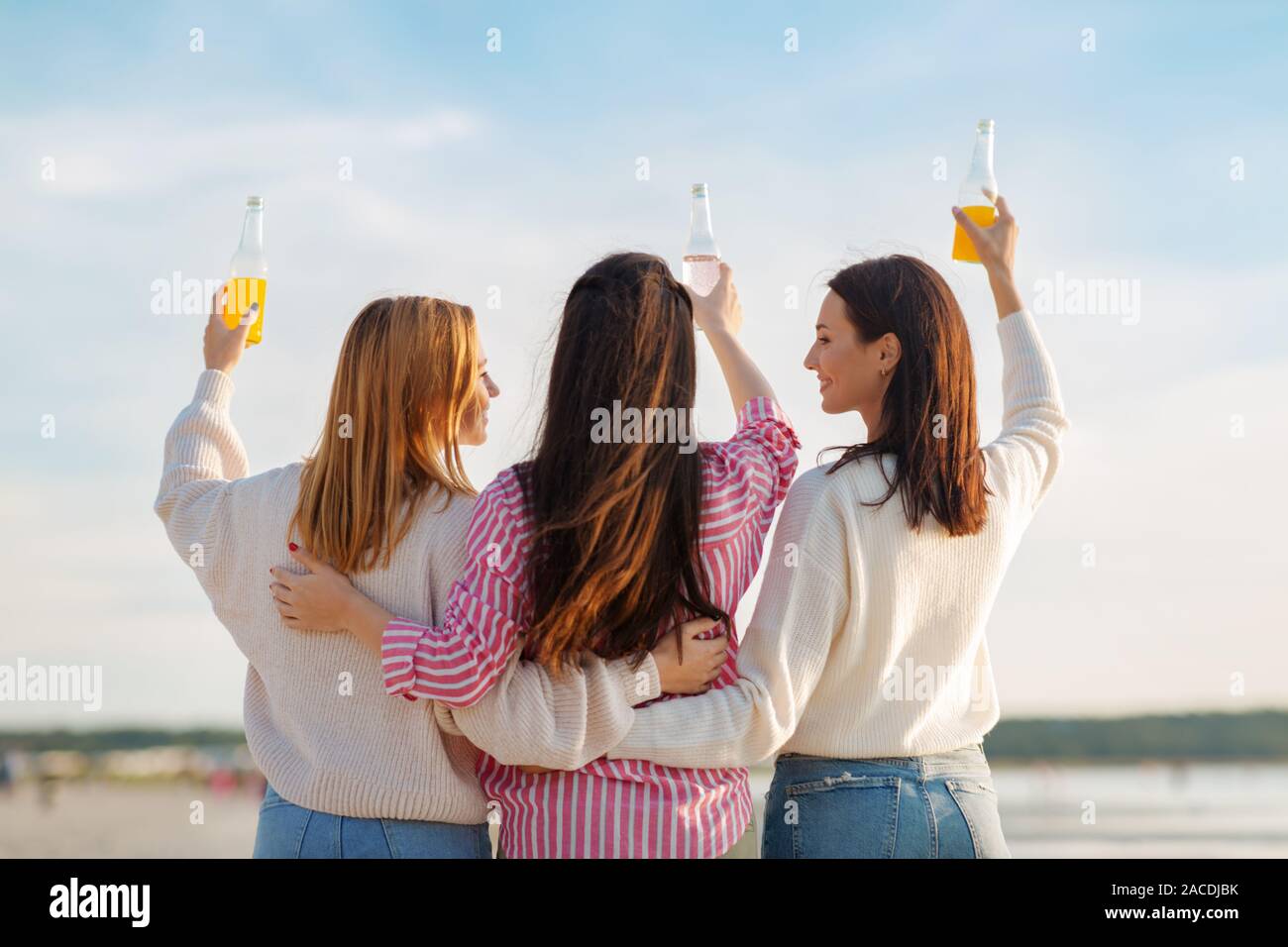 Les jeunes femmes toasting non alcoolisées on beach Banque D'Images