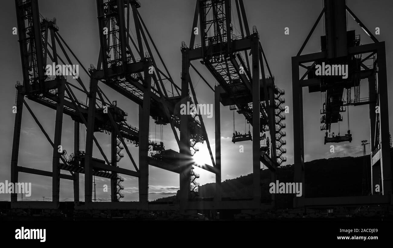 Noir et blanc quais de chargement du port au coucher du soleil Banque D'Images
