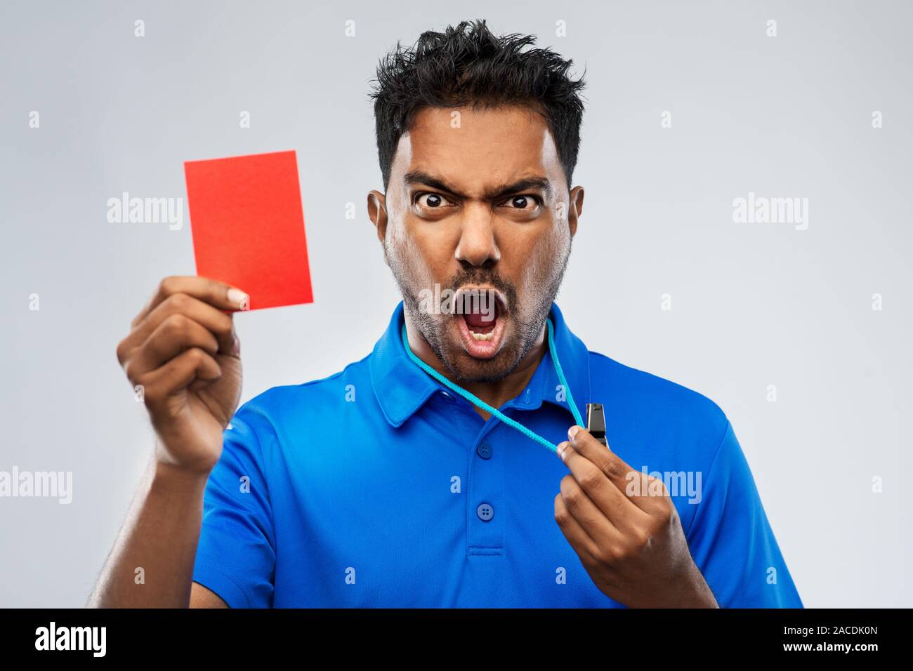 Les indiens en colère avec sifflet arbitre montrant carte rouge Banque D'Images