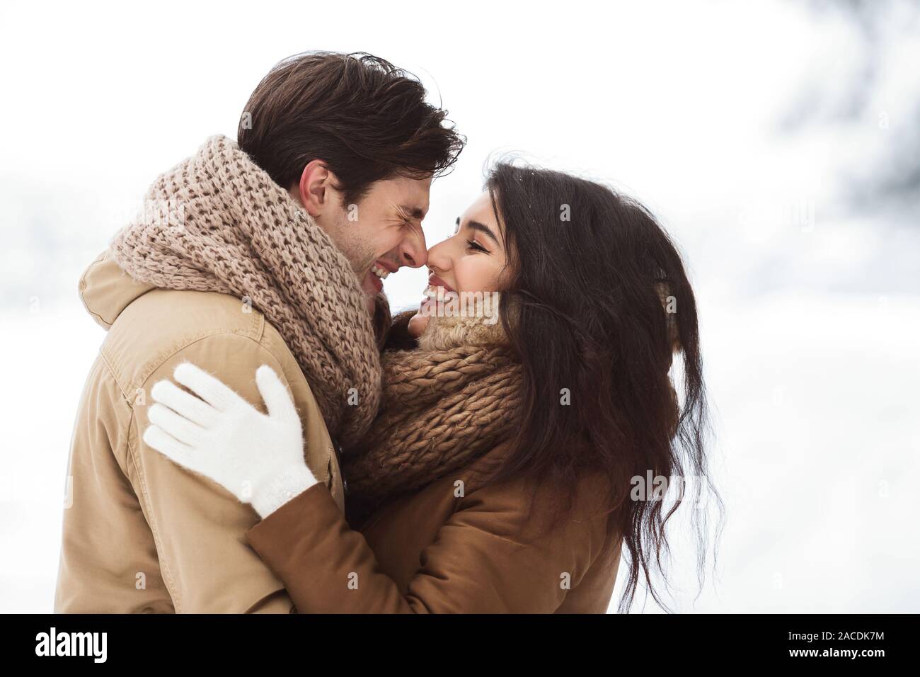 Couple doux Frotter leur nez Hugging Standing In Snowy Forest Banque D'Images
