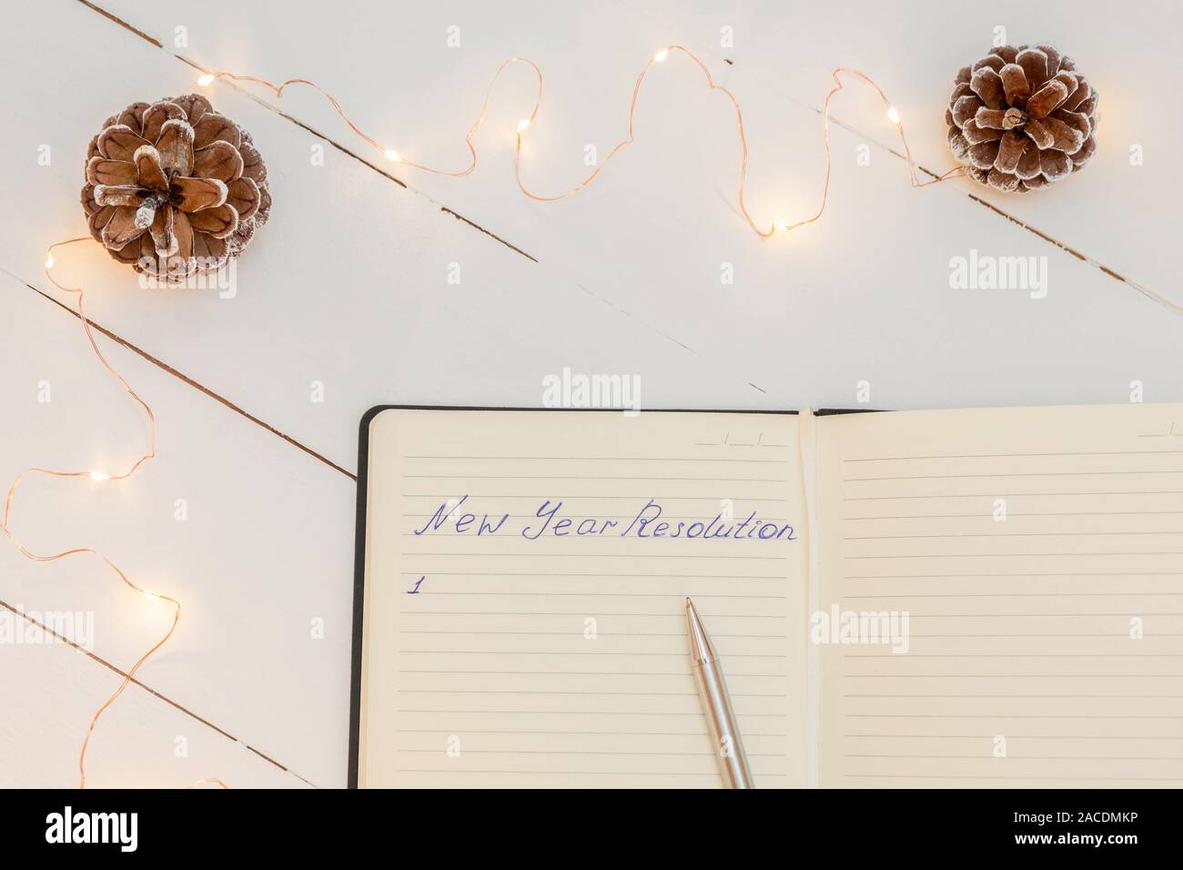 Bloc-notes avec texte manuscrit 'Résolution' Nouvel An sur table en bois blanc et de décorations de Noël Banque D'Images