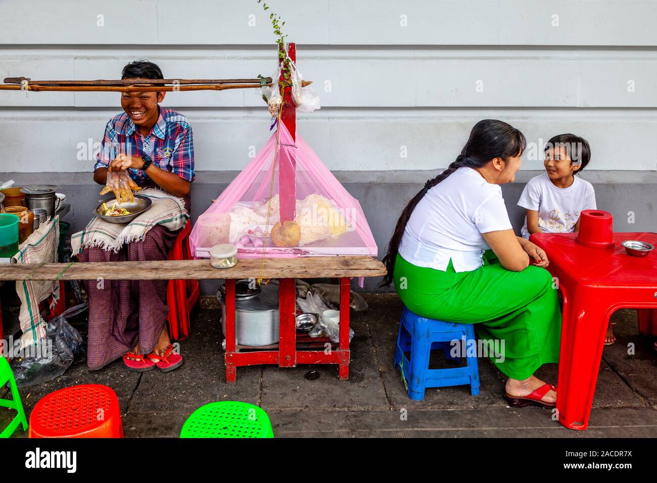 Une femme et un enfant assis à une table à la Street Food, Yangon, Myanmar. Banque D'Images